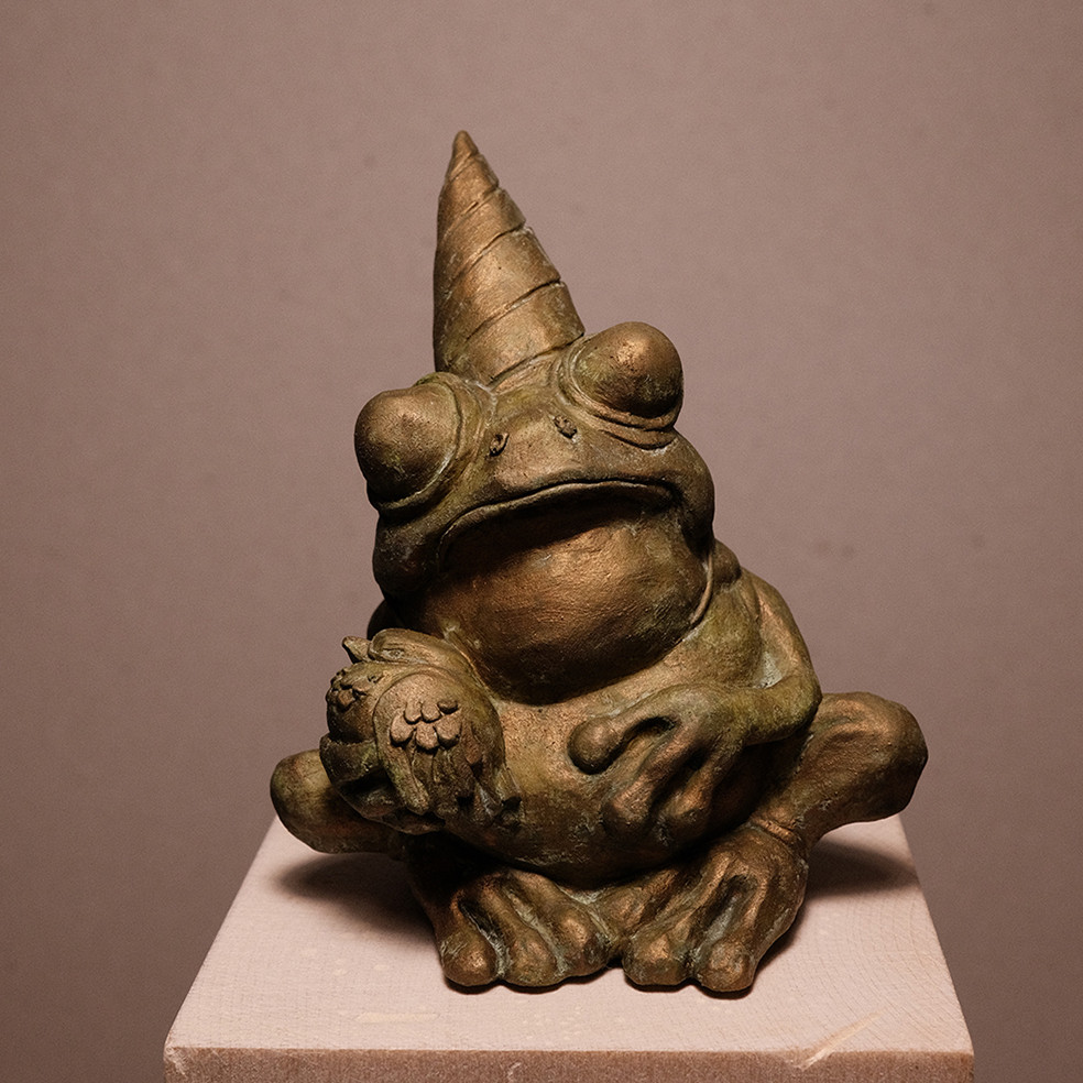 Photo details of the sculpture "Fête des crapauds" 2023, polymer clay, green-gold patinated resin version, created by the artist Teddy Ros, representing a frog with a bird, image 01