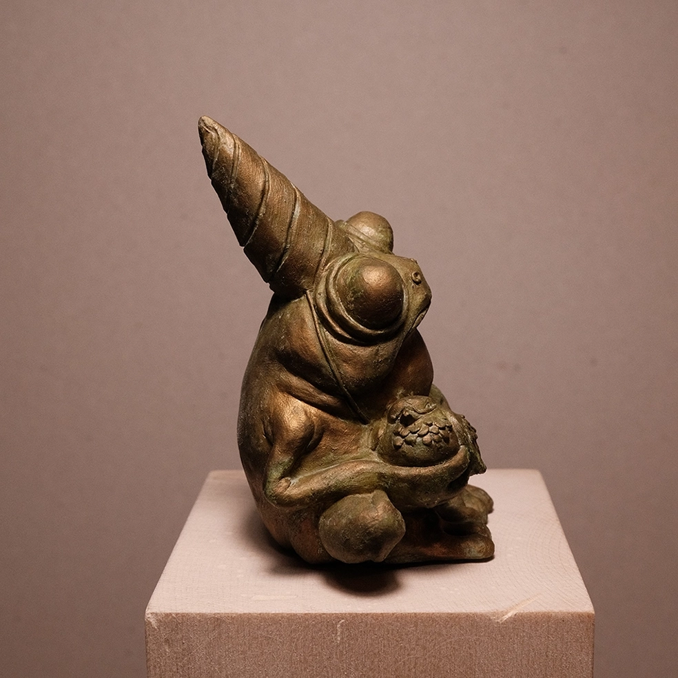 Photo details of the sculpture "Fête des crapauds" 2023, polymer clay, green-gold patinated resin version, created by the artist Teddy Ros, representing a frog with a bird, image 02