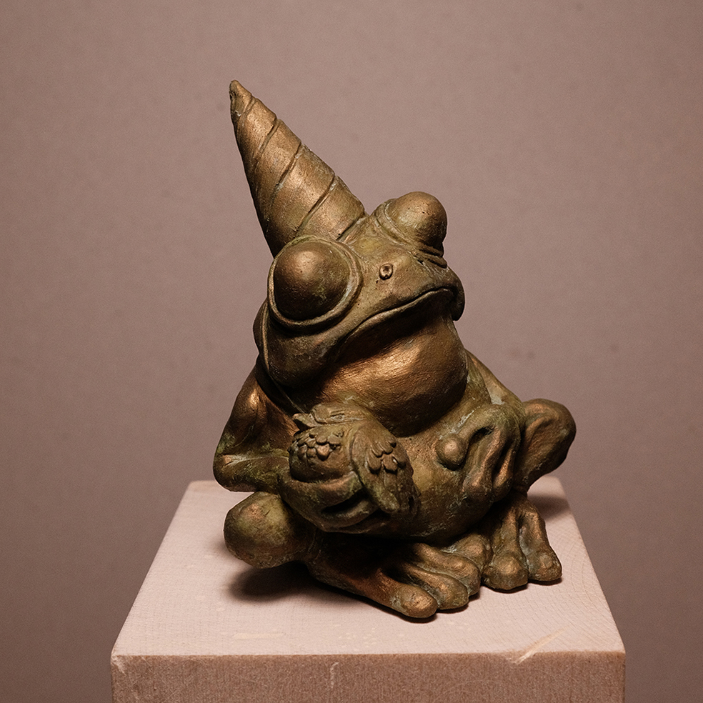 Photo details of the sculpture "Fête des crapauds" 2023, polymer clay, green-gold patinated resin version, created by the artist Teddy Ros, representing a frog with a bird, image 04.